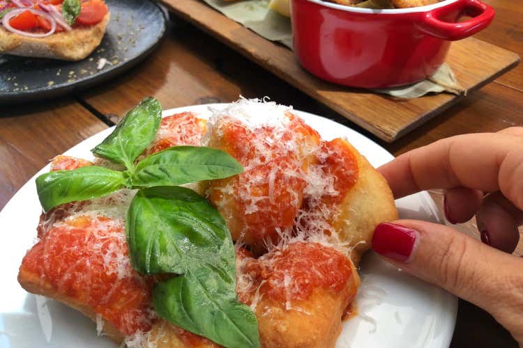 Montanarine, Pizza fritta con sugo di pomodoro, olio al basilico e scaglie di Grana Viaggio culinario on the road all’Isola Tiberina con Queen Makeda