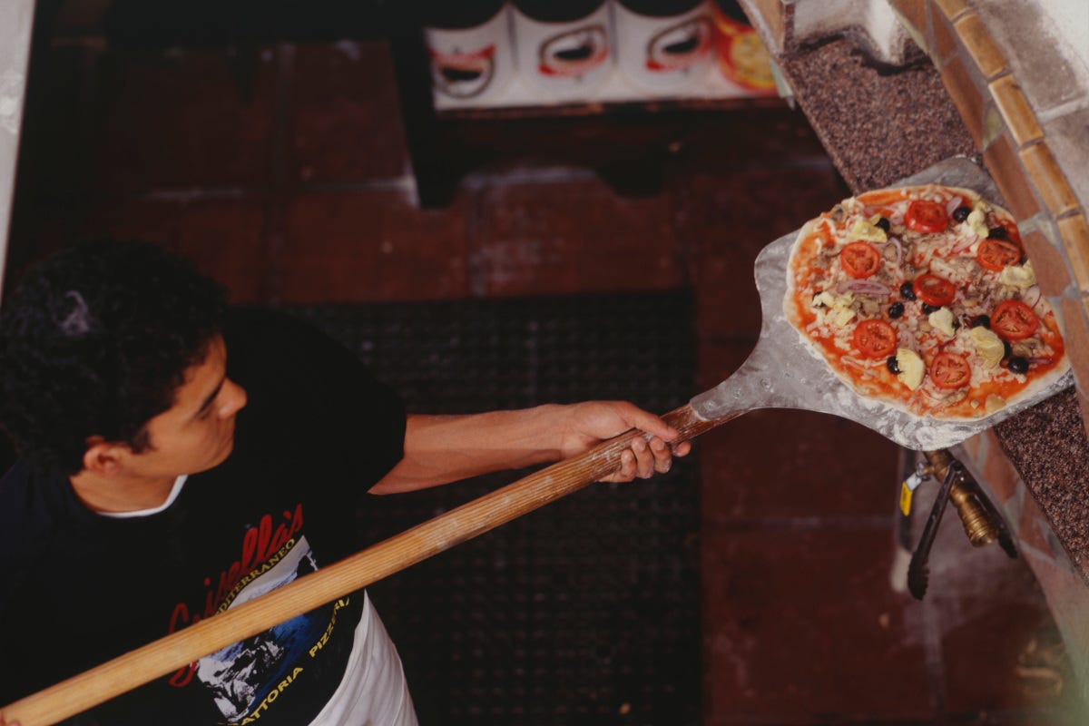 Pizzaiolo al lavoro  La pizza non conosce crisi: l’impasto più amato è quello napoletano