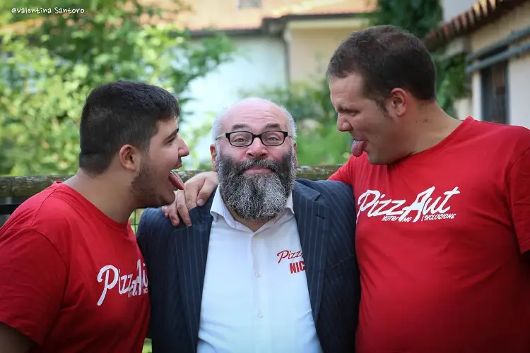 Al centro Nico Acampora con due ragazzi che lavorano a PizzAut Ristorazione e inclusione: la ricetta di PizzAut che d&agrave; lavoro ai ragazzi autistici
