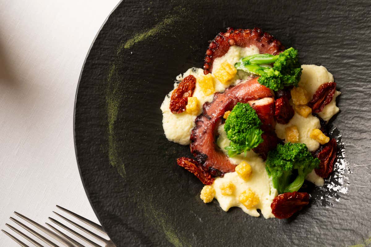 Polpo in doppia cottura su spuma di patate di Polignano, cime di rapa, pomodorini confit e croccante di polenta, dell'Osteria di Chichibio