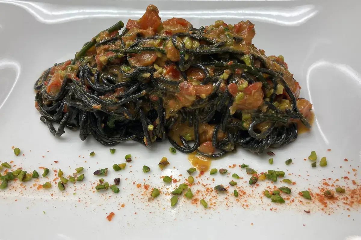 Chitarrina al nero al pesto di datterini e pistacchio di bronte con riccio di mare e salicornia Chitarrina al nero al pesto di datterini e pistacchio di bronte con riccio di mare e salicornia