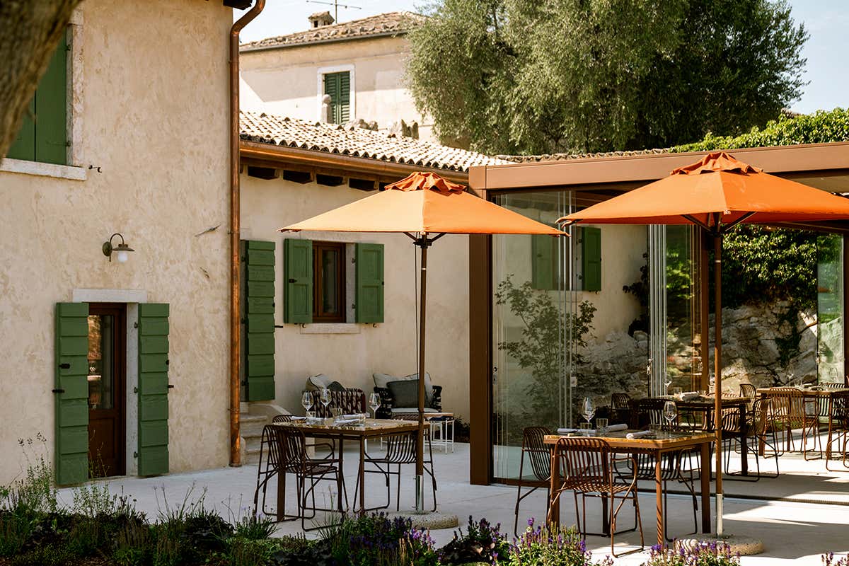 Il luminoso patio esterno del Riviera Restaurant, dove tavoli all'aperto e ombrelloni accolgono gli ospiti per un'esperienza gastronomica immersa nella quiete del luogo