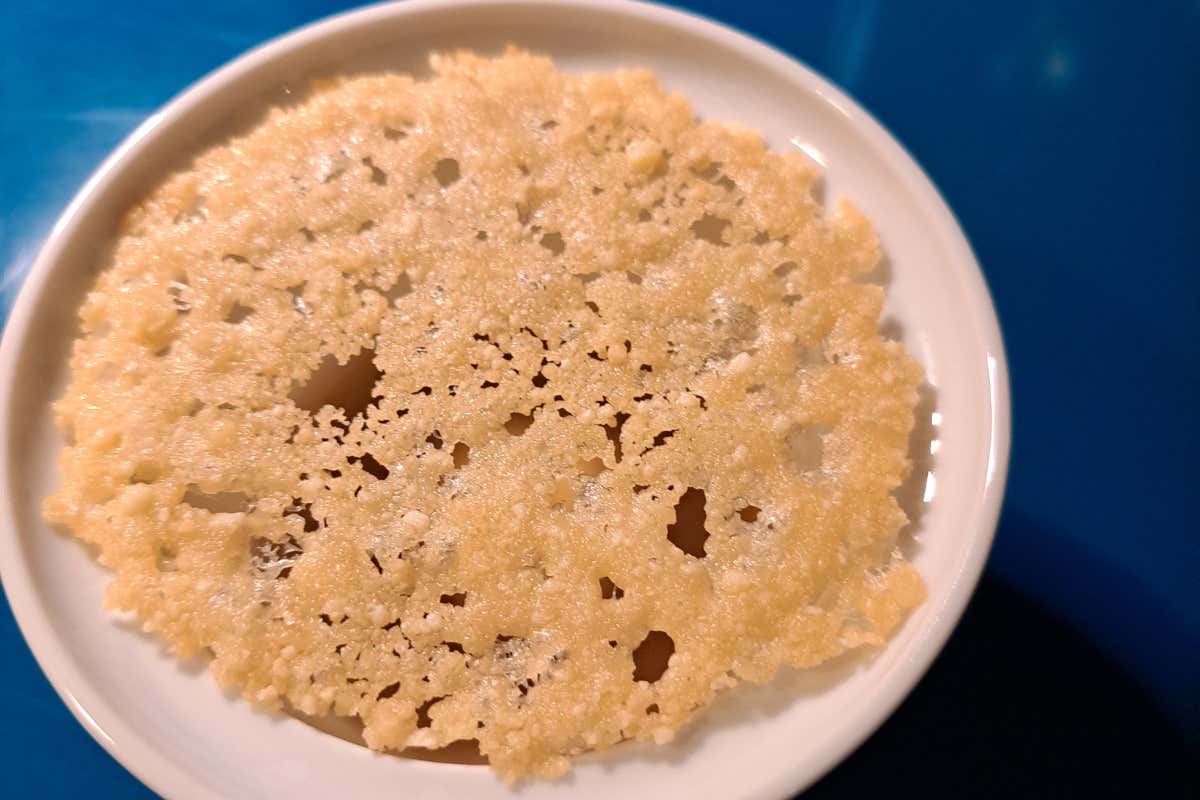 Stuzzichino di benvenuto: crema di sedano rapa coperta da un brodo di champignon, completata da una cialda di Grana Padano stagionato trenta mesi