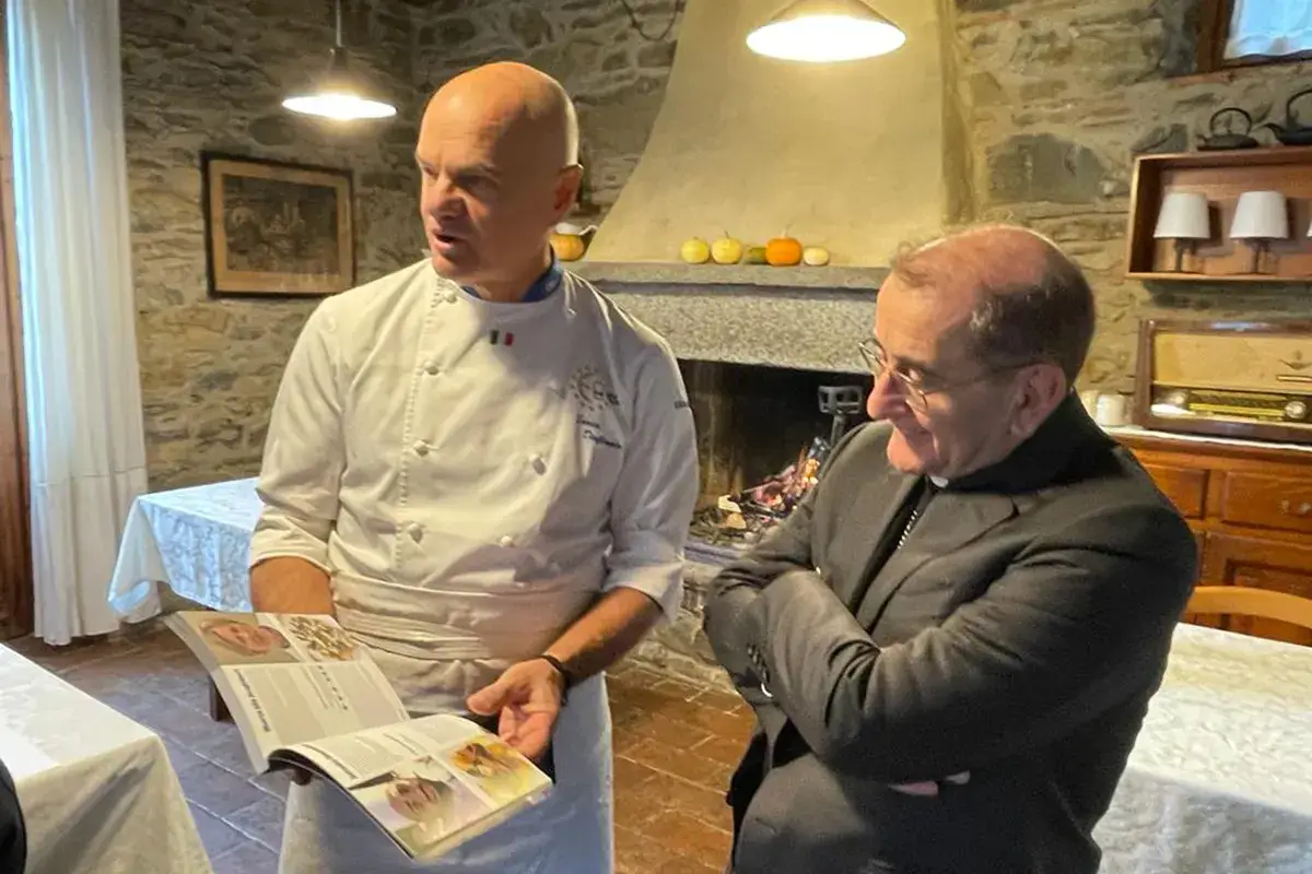 Enrico Derflingher con la guida in mano insieme all'Arcivescvo di Milano