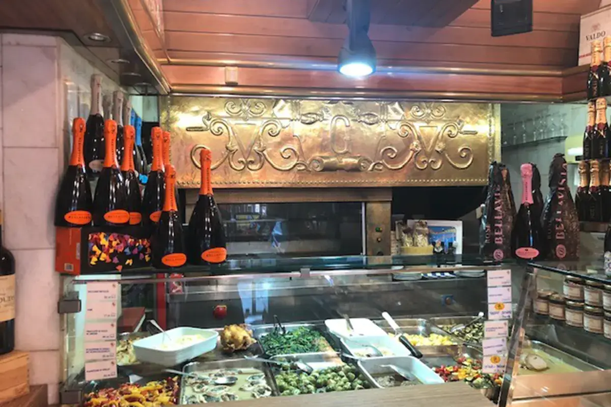 Il banco della Rosticceria Galli con il girarrosto alle spalle Botteghe storiche e negozi alimentari di vicinato, resistenza sulla via della ripresa