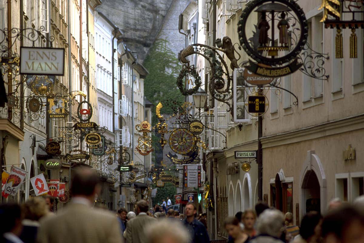 Via Getreidegasse con insegne in ferro battuto oppure dettaglio di Mozartkugeln artigianali