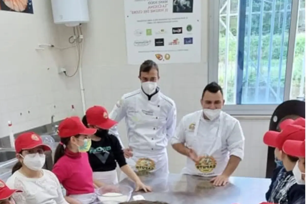 Al centro da sinistra Christian Aprile e Davide Citiello con gli alunni dell'istituto comprensivo di Castellamare Contro l'abbandono scolastico si fanno... le pizze