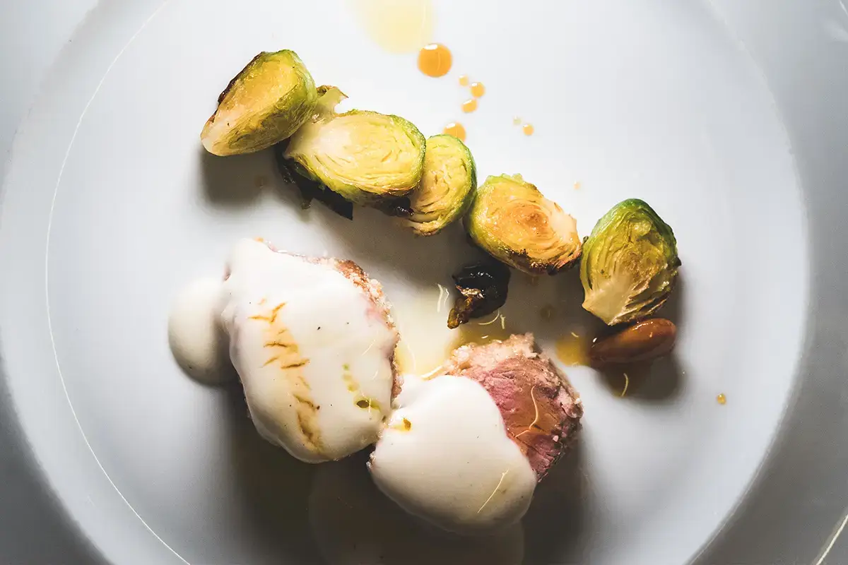 Filetto di maialino Patanegra in crosta di mandorla, laccato al Grana Padano Dop 18 mesi, cavoletti di Bruxelles caramellati &ldquo;Nati per stare insieme&rdquo; da Tano Passami l&rsquo;Olio