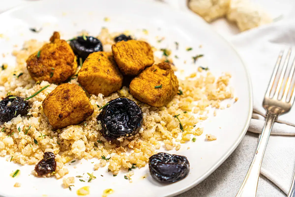 Riso di cavolfiore tostato con bocconcini di pollo al curry, Prugne della California ed erbe aromatiche Riso di cavolfiore tostato con bocconcini di pollo al curry, Prugne della California ed erbe aromatiche
