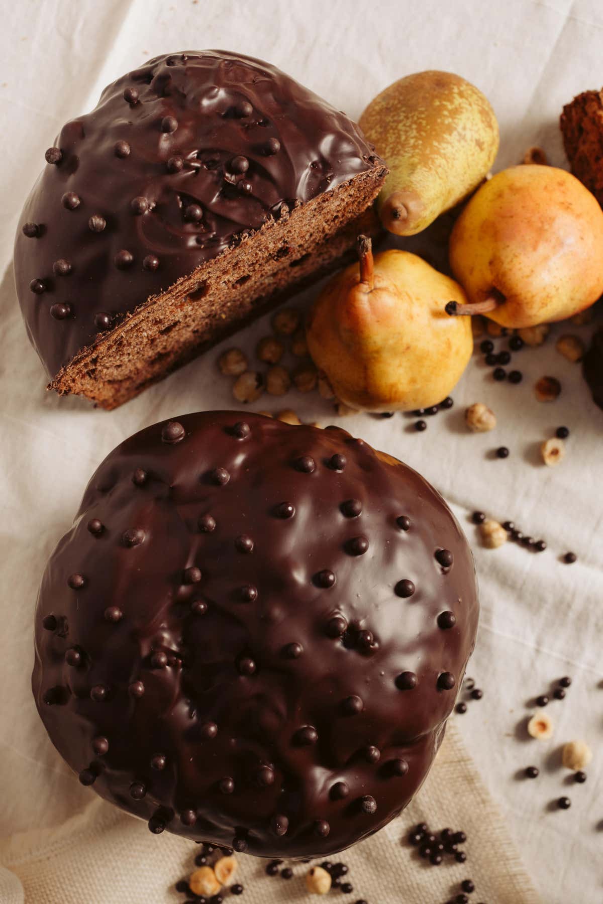 Un panettone che rompe con la tradizione cromatica grazie a un impasto scuro al cioccolato, profondo e avvolgente. Le pere candite rilasciano freschezza e succosità, mentre il gianduia crea un equilibrio tra acidità fruttata e dolcezza fondente. Una proposta pensata per chi ricerca intensità e rigore esecutivo.