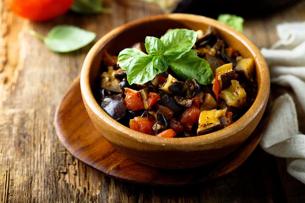 La caponata siciliana, simbolo della cucina mediterranea, unisce verdure e sapori agrodolci tipici della tradizione