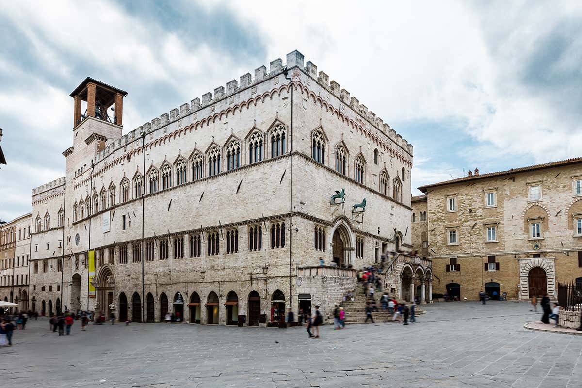 La maestosa facciata gotica di Palazzo dei Priori, sede del potere cittadino e scrigno dei capolavori della Galleria Nazionale dell'Umbria