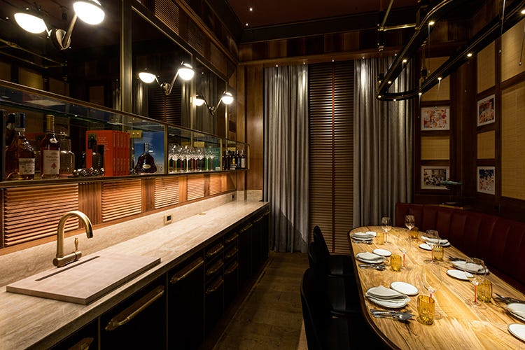 Una grande boiserie in legno di noce zigrinato che richiama il bancone del ristorante (Una stanza privata per Langosteria Massimo in 10, musica a scelta)