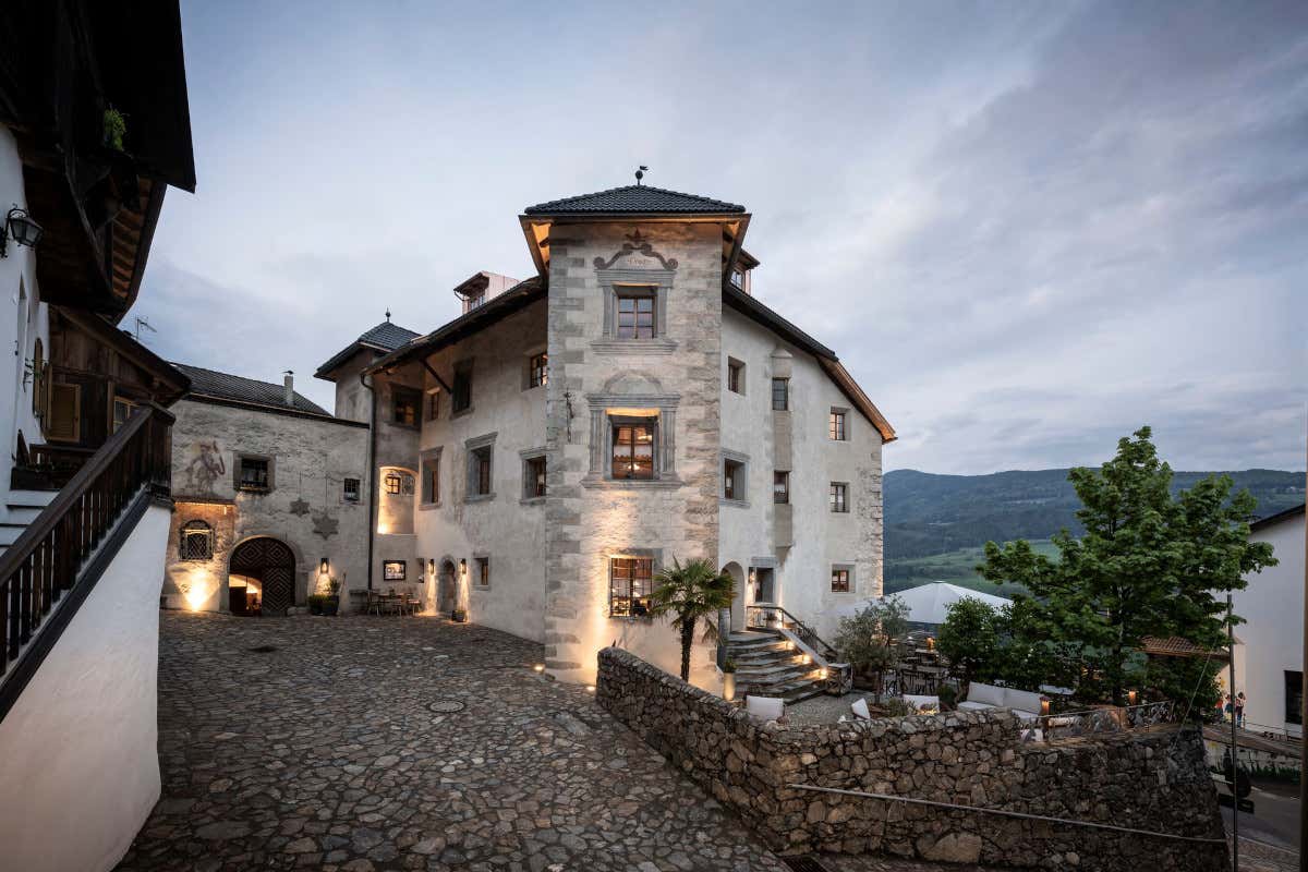 Castel Steinbock l'Alto Adige d'autunno, boschi infuocati con le Dolomiti sullo sfondo