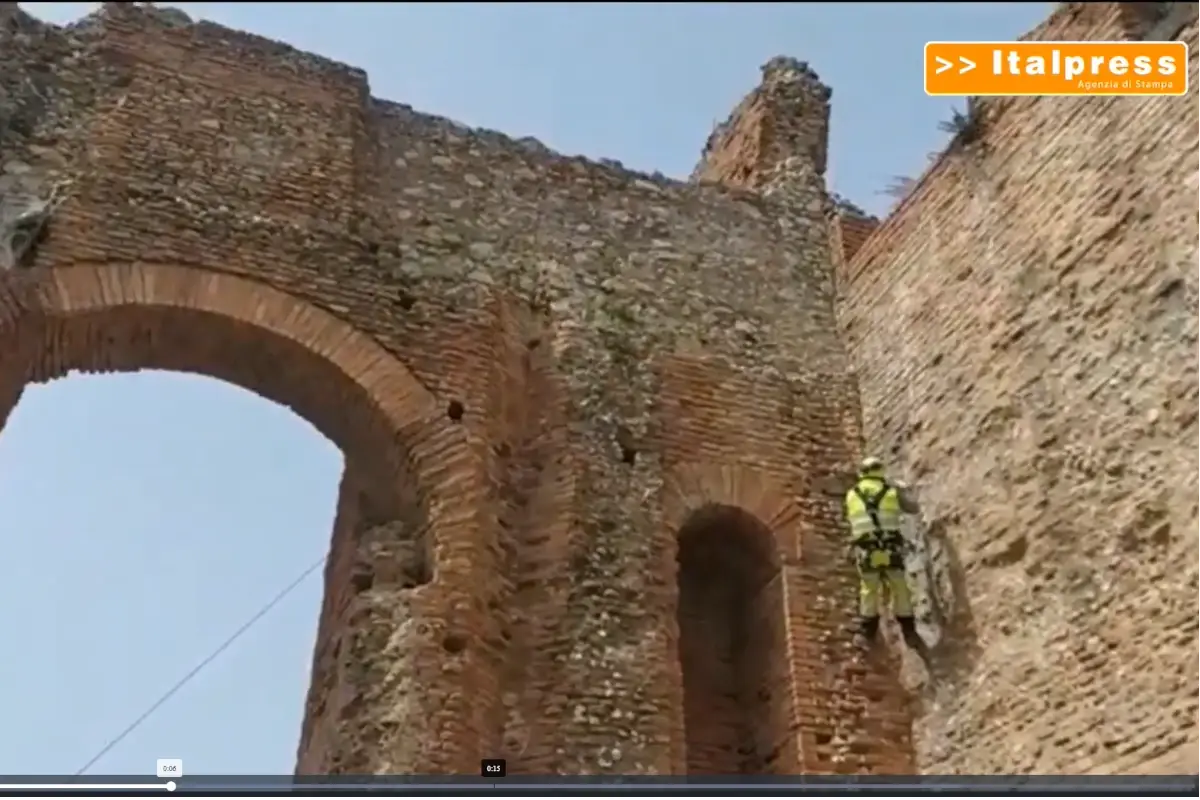 Operai al lavoro al Teatro Antico di Taormina Rocciatori scalano il Teatro Antico di Taormina per ripulirlo