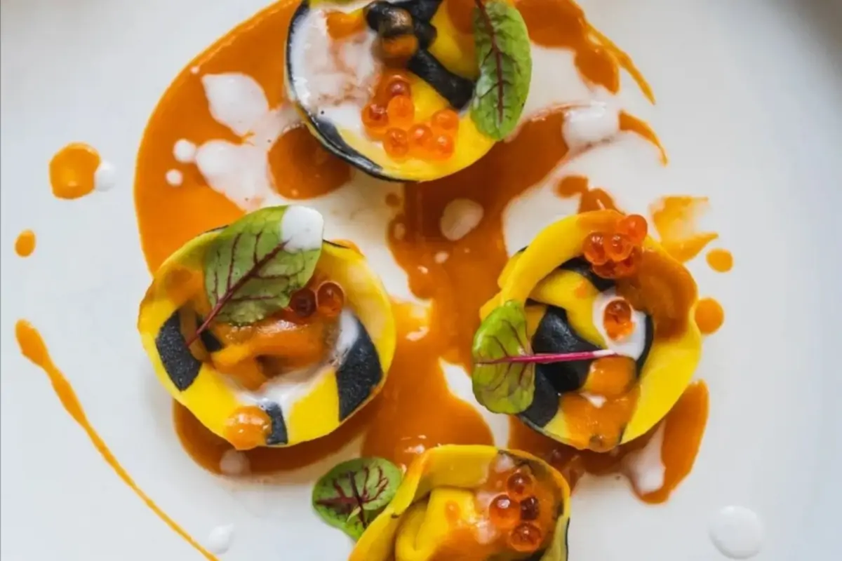 I Tortelli di pasta fresca bicolore di Giuseppe Guard&igrave; Tortelli di pasta fresca bicolore, con ripieno di astice, granchio e lime, bisque di gambero, spuma di cocco e uova di trota