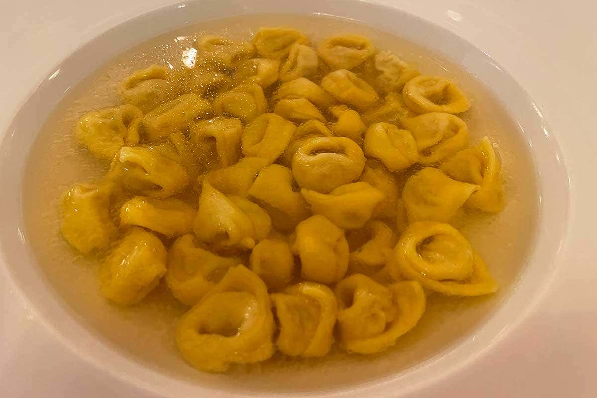 Tortelini in doppio brodo di cappone. Ripieno: lonza di maiale, mortadella, prosciutto crudo, noce moscata, sale, Parmigiano Reggiano Il Majestic di Bologna cambia faccia: in cucina il giovane Guglielmo Araldi