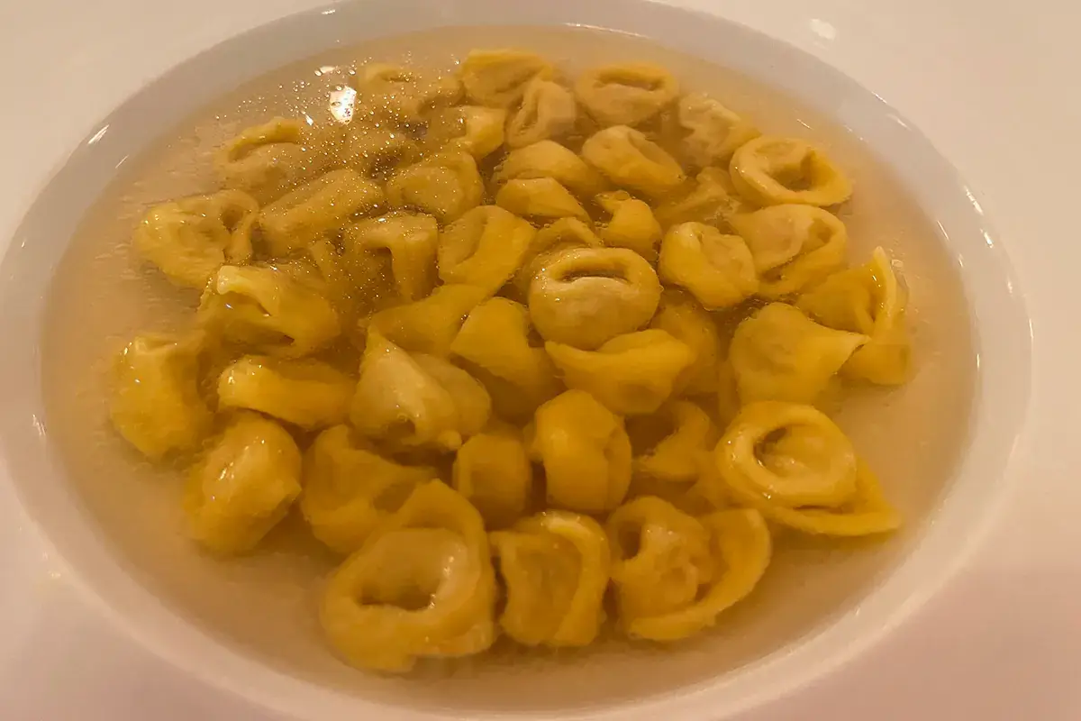 Tortelini in doppio brodo di cappone. Ripieno: lonza di maiale, mortadella, prosciutto crudo, noce moscata, sale, Parmigiano Reggiano Il Majestic di Bologna cambia faccia: in cucina il giovane Guglielmo Araldi