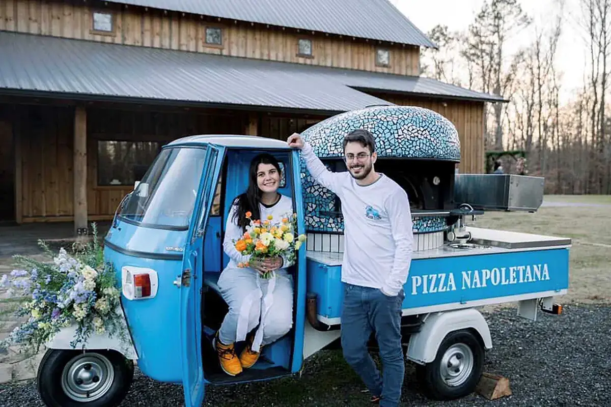 Da destra, Alessio Lacco con la moglie sulla loro ApeCar con forno a legna per la pizza Pizza on the road, arriva la certificazione dall'Associazione verace Pizza Napoletana