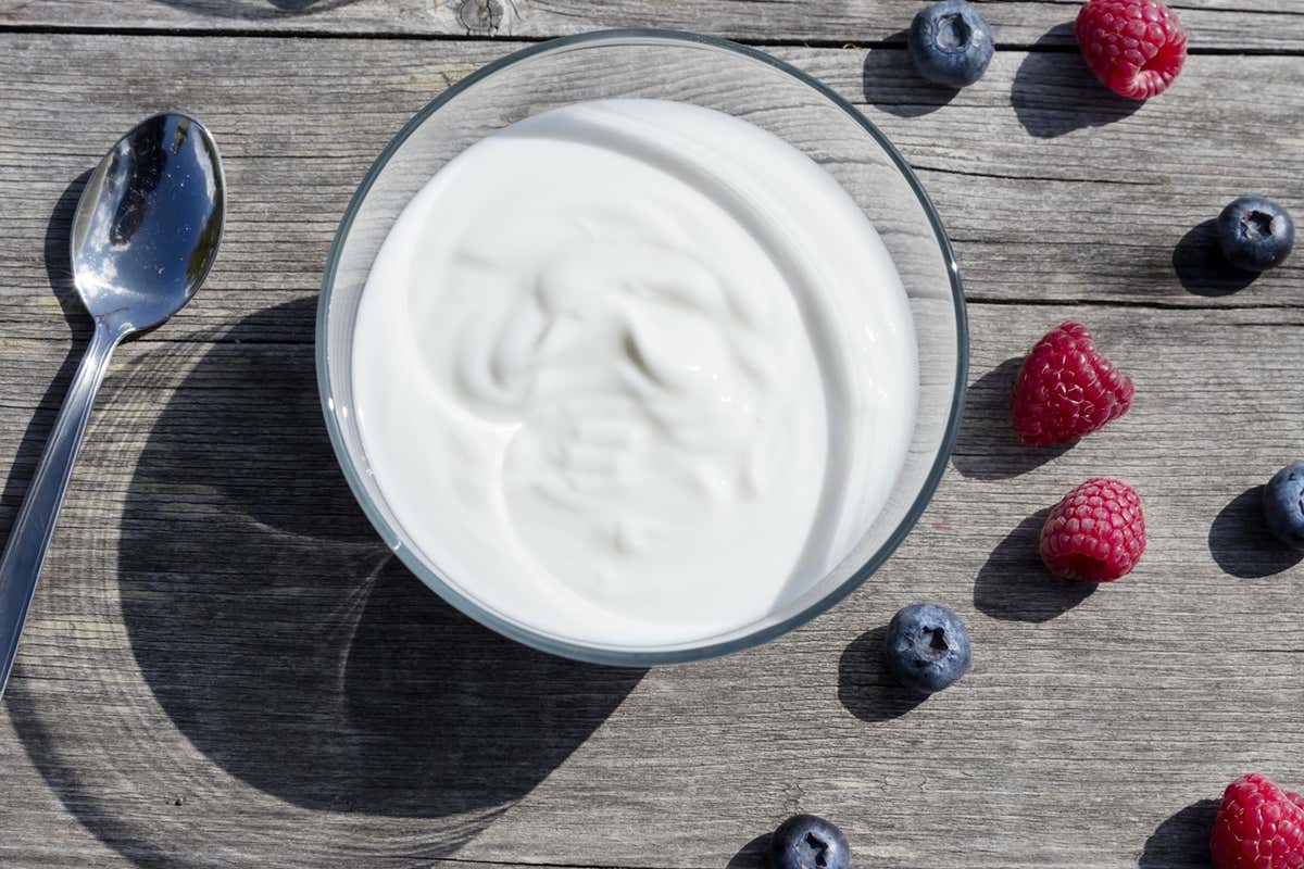 Una ciotola di Yogurt Vipiteno servita all'aperto, accompagnata da piccoli frutti freschi di montagna durante le giornate dello Yogurtsummer