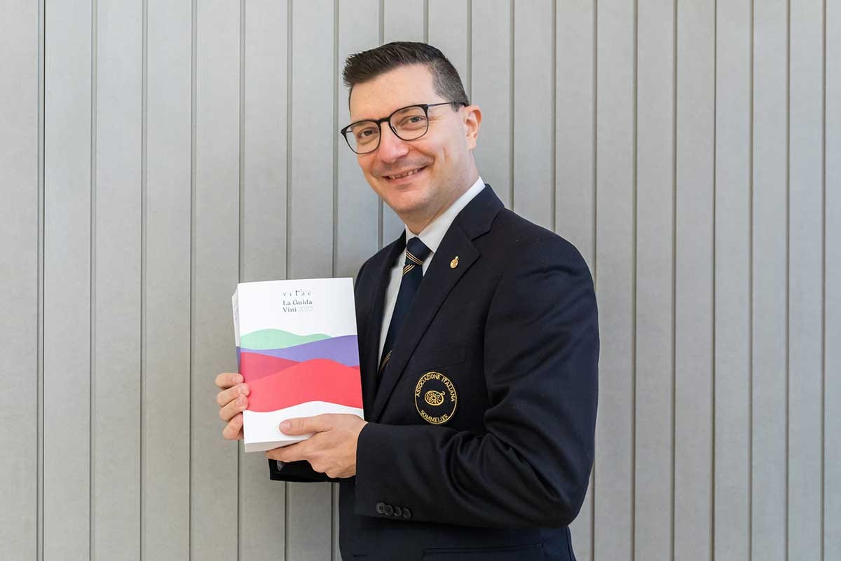 Nicola Bonera con in mano una copia di Vitae Vitae 2022, la guida dei sommelier italiani ai migliori vini tricolore