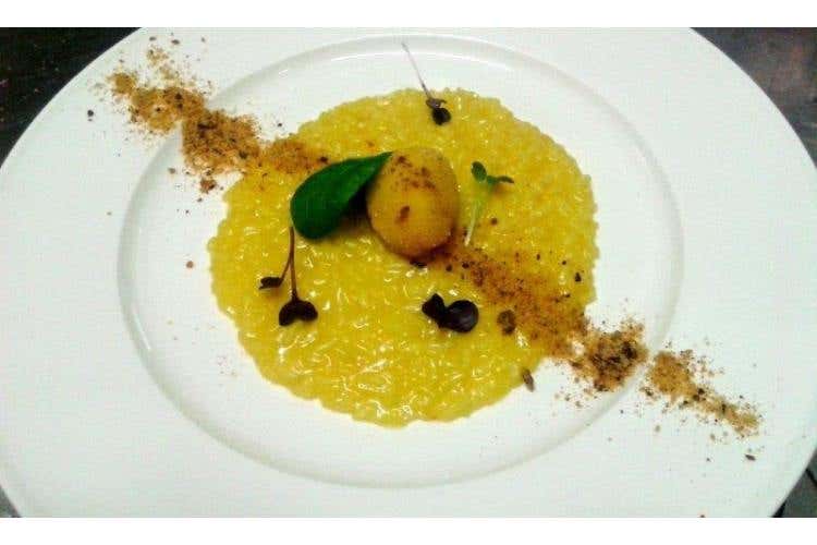 Risotto allo zafferano, con sfera di formaggio di capra e polvere di Panettone