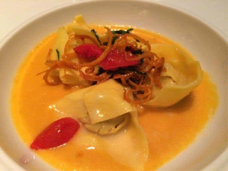 Ravioli ripieni di prosciutto di Cinta Senese con coulis di pomodorini gialli Pachino caramellati all’arancio candito. Abbinamento: Rosso di Montalcino 2012 - Casanova di Neri