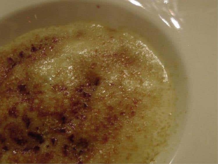 Crema bruciata con mirtilli ghiacciati, ciliegie e meringhe