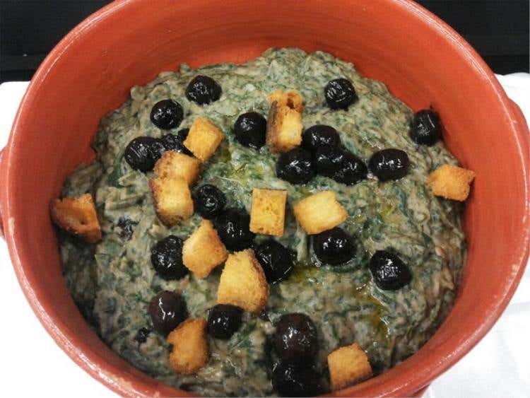 Impanata di fave e cicorie con olive fritte, accompagnata da crostini fritti