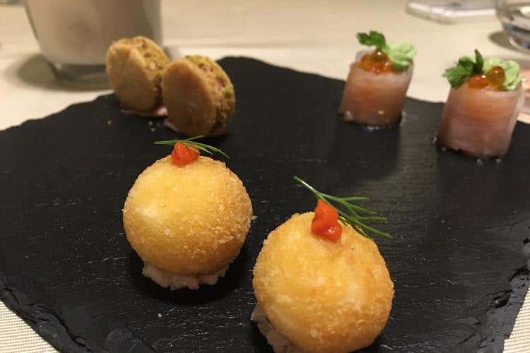 Aperitivo (composto da Bon Bon di mozzarella acciuga e peperone piquillo, Sablé mortadella e pistacchio, Roll di daykon salmone in tartare)