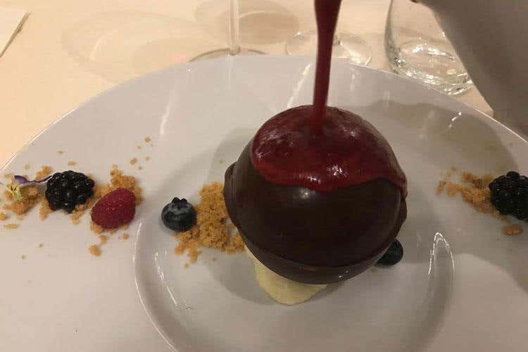 Sfera di cioccolato fondente con cremoso di cioccolato bianco e caramello con colata di lamponi (Ristoranti Regionali Cucina Doc 
Il Giardino di Cles nuovo associato)