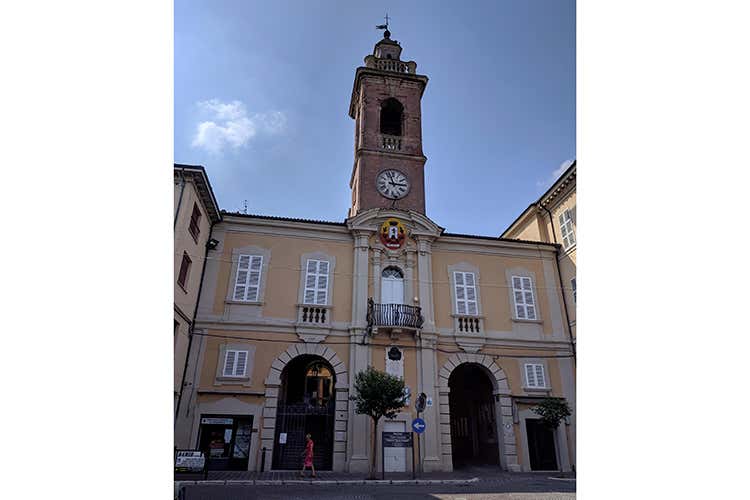 La facciata del comune di Mendola: la torre è più antica, le mura accanto sono state costruite per evitarne il crollo nel tempo